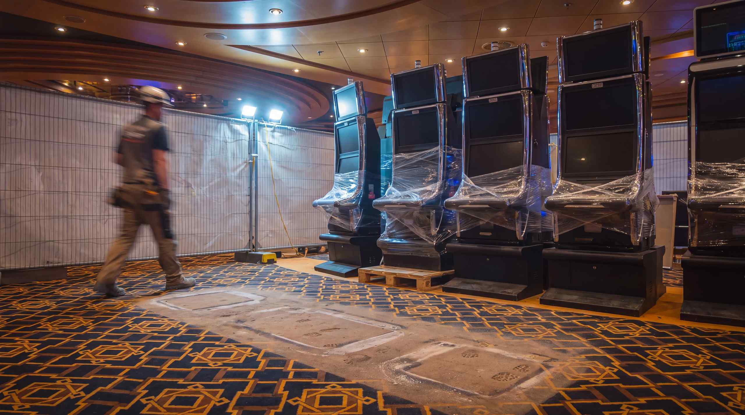 An empty casino floor with slot machines that are shut down and wrapped up.